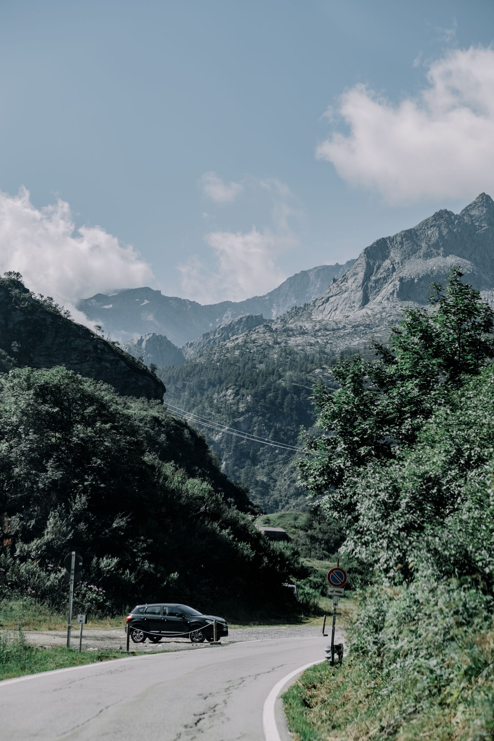 Open road through dramatic landscape with mountains and coastline
