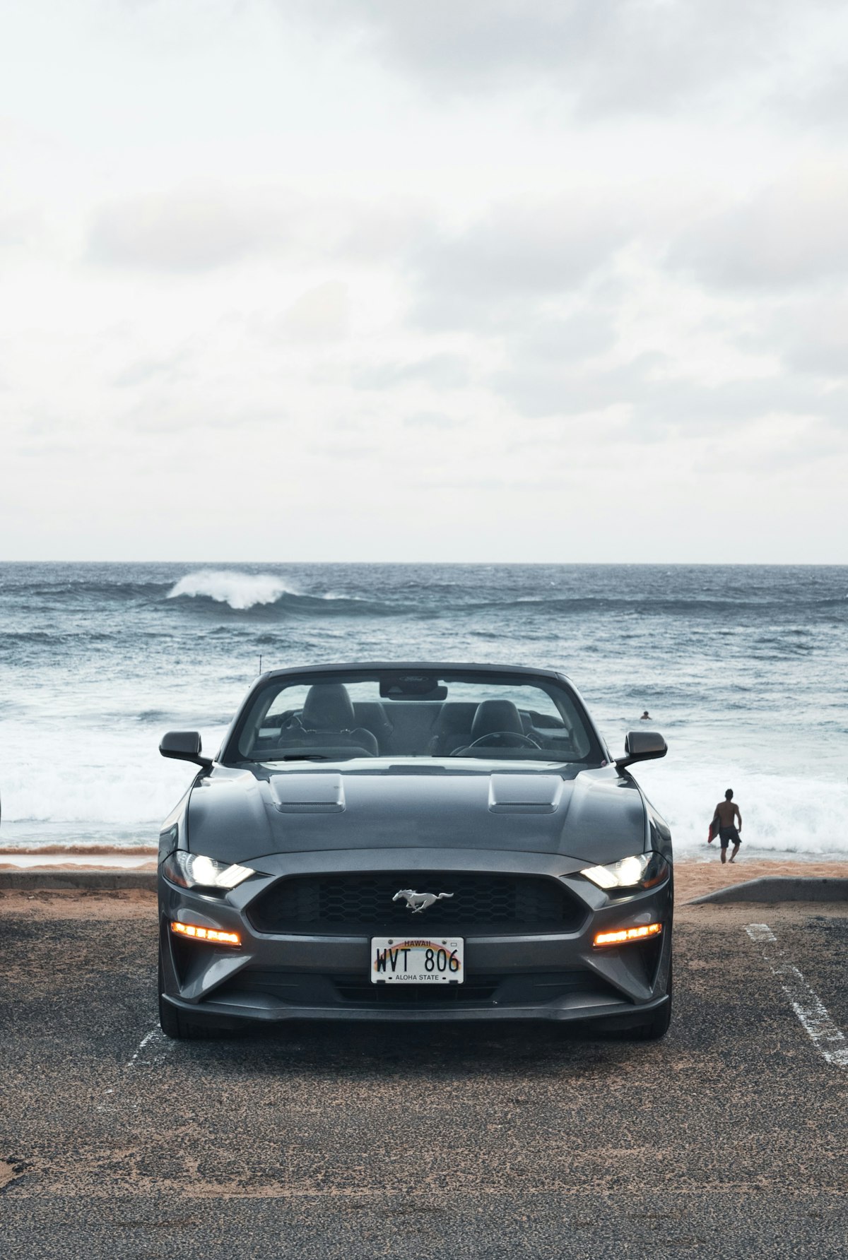 Light-colored convertibles on a sunny coastal road