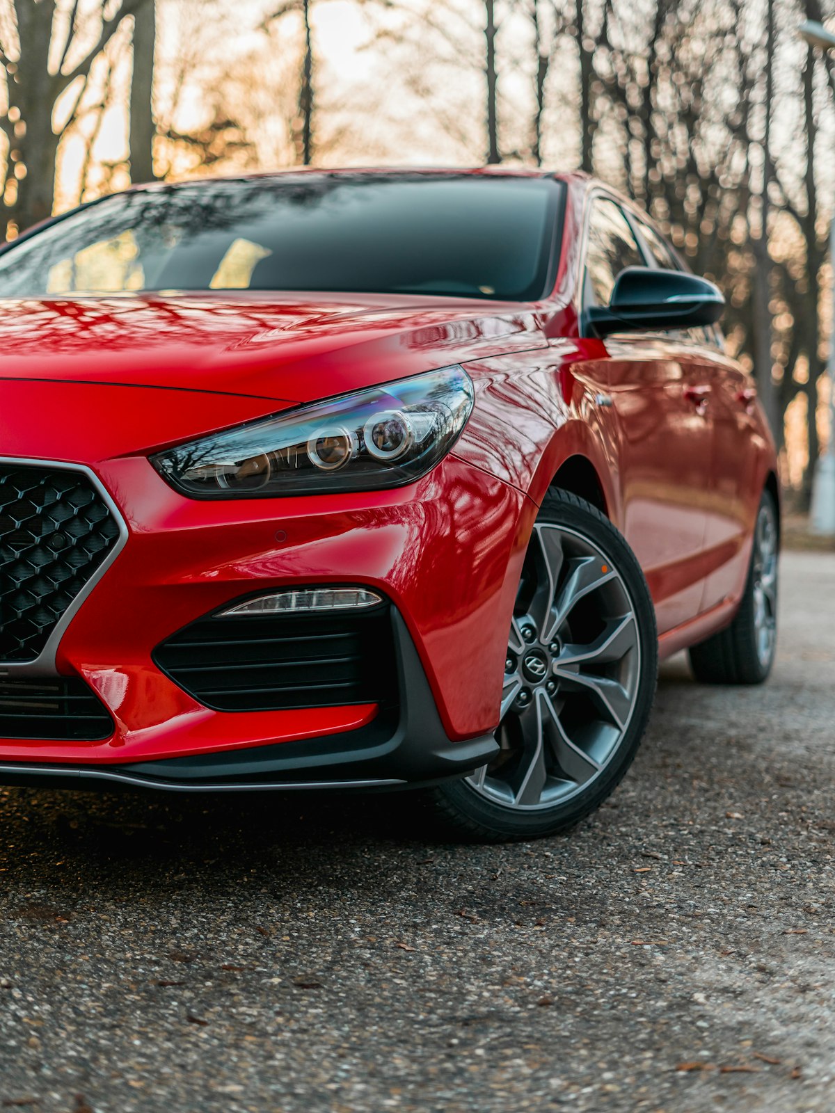 Red economy sedan parked at a car rental lot