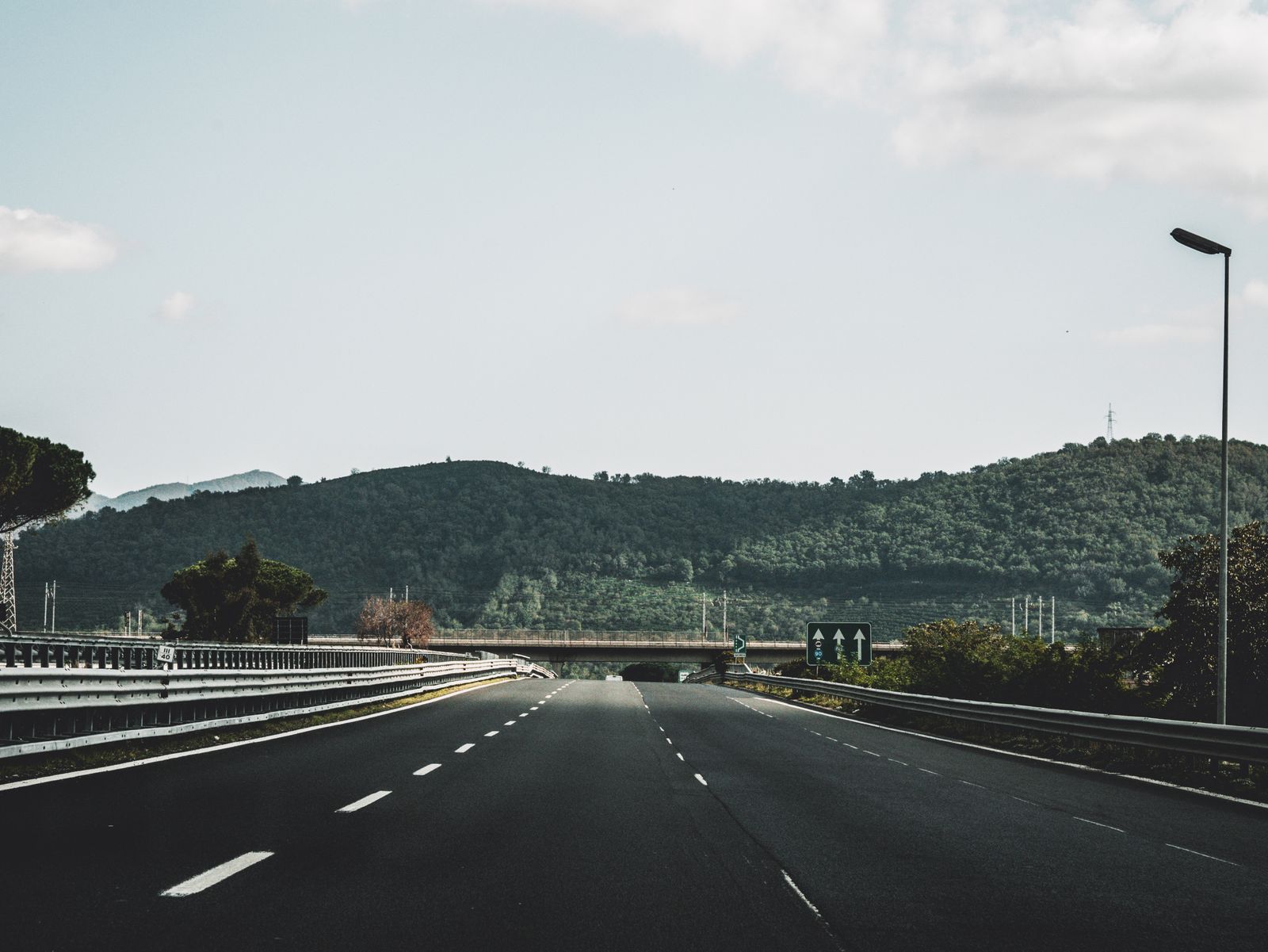 Autopista italiana (autostrada) entre colinas con señalización de carriles