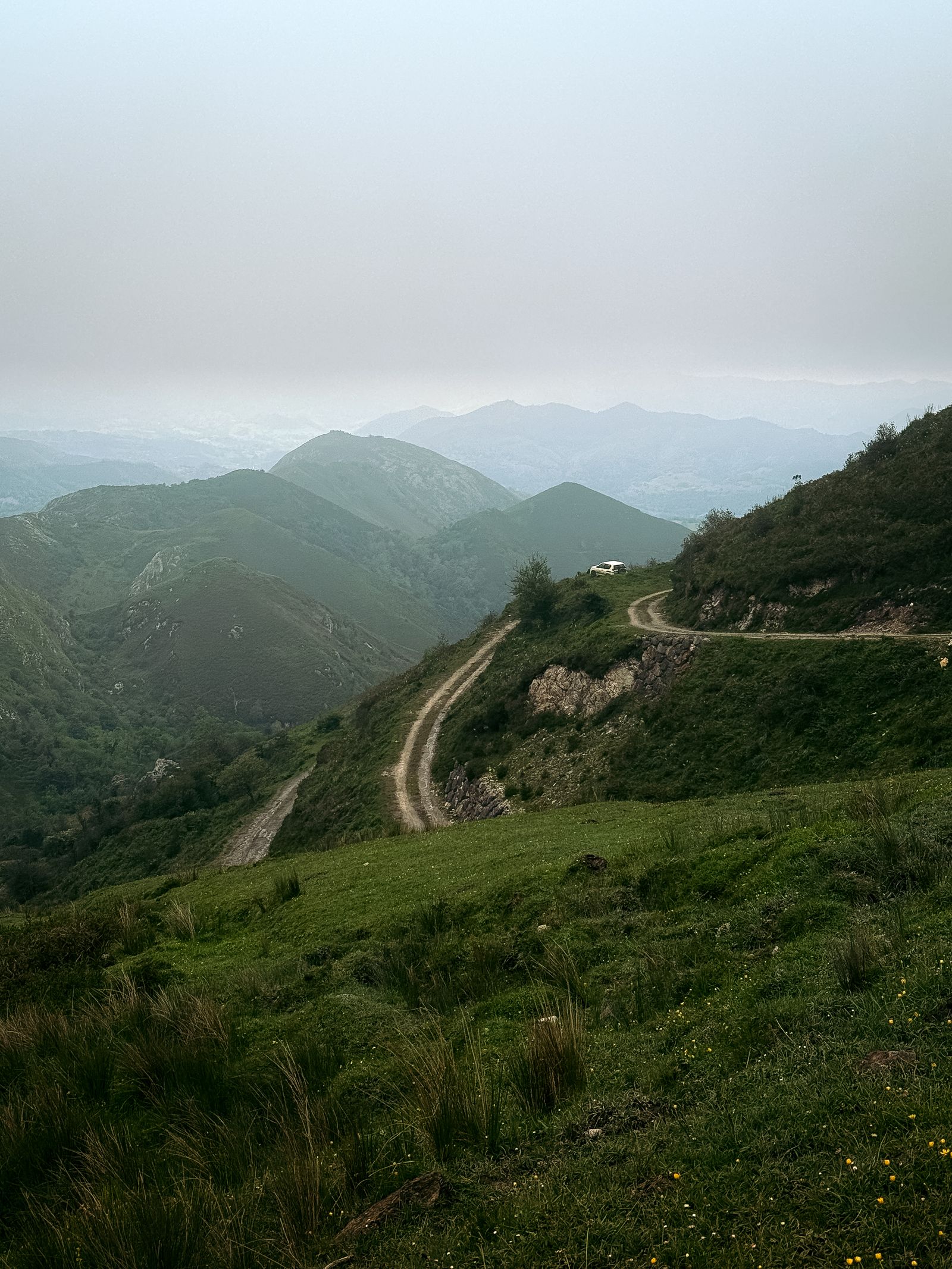Winding coastal road in northern Spain with green cliffs and Atlantic Ocean