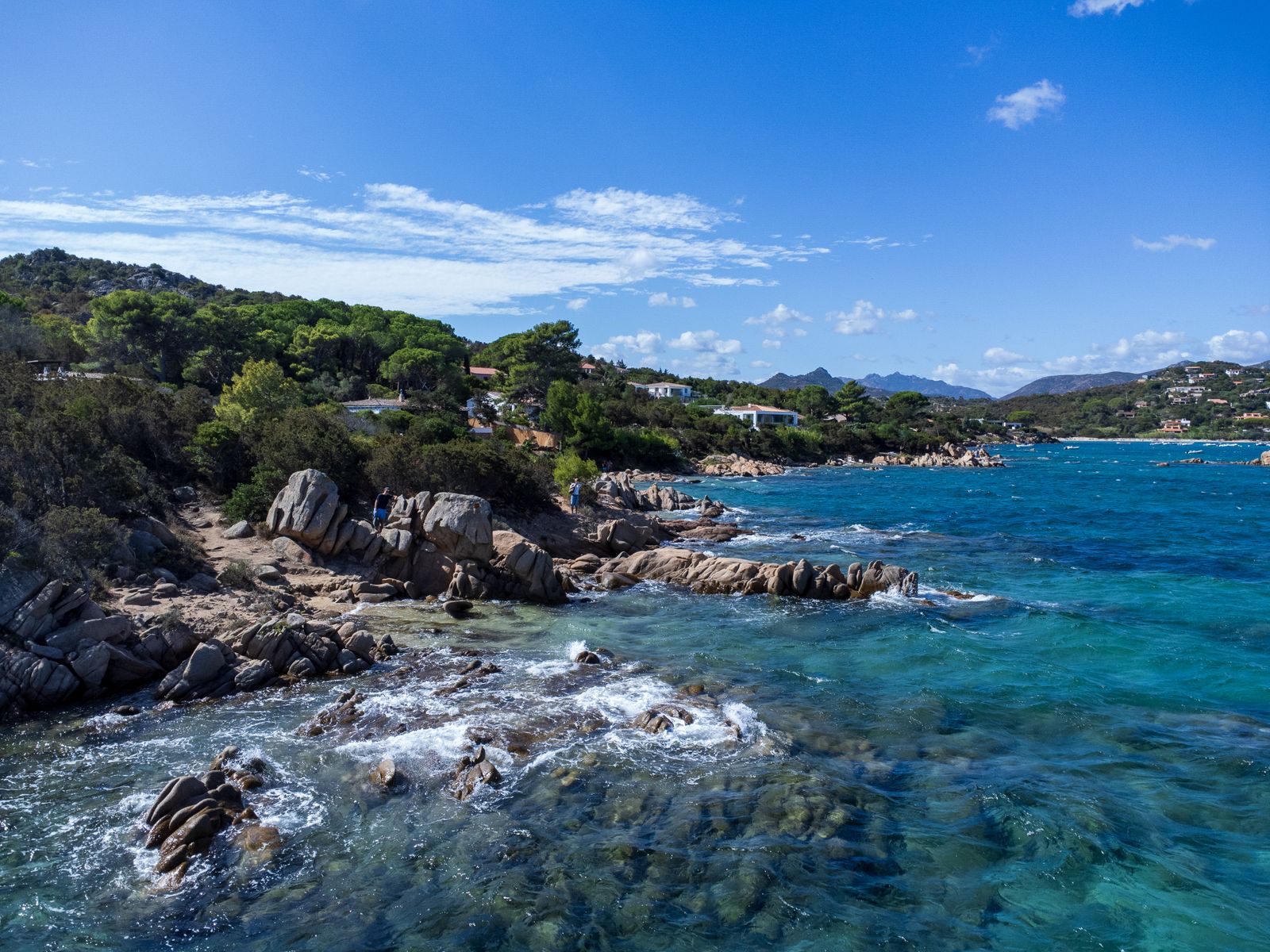Empty coastal road in Sardinia with turquoise water visible below
